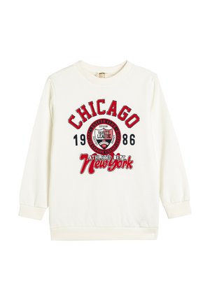 Sudadera blanca de manga larga, con gráficos en rojo y negro: "CHICAGO 1986" y "DEPARTAMENTO ATLÉTICO. Nueva York." Puños y cuello acanalados.