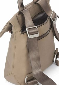 Mochila color topo con correas marrones ajustables, hebillas metálicas y una cremallera superior parcialmente abierta que revela el forro interior oscuro.