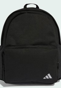 Mochila de tela negra con forma redondeada, que cuenta con un bolsillo frontal con cremallera y un logo reflectante en la esquina inferior derecha.