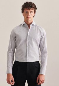 Camicia a maniche lunghe a righe bianche e blu navy con colletto a punta, bottoni frontali e polsini con bottoni; tessuto di cotone liscio e vestibilità sagomata.