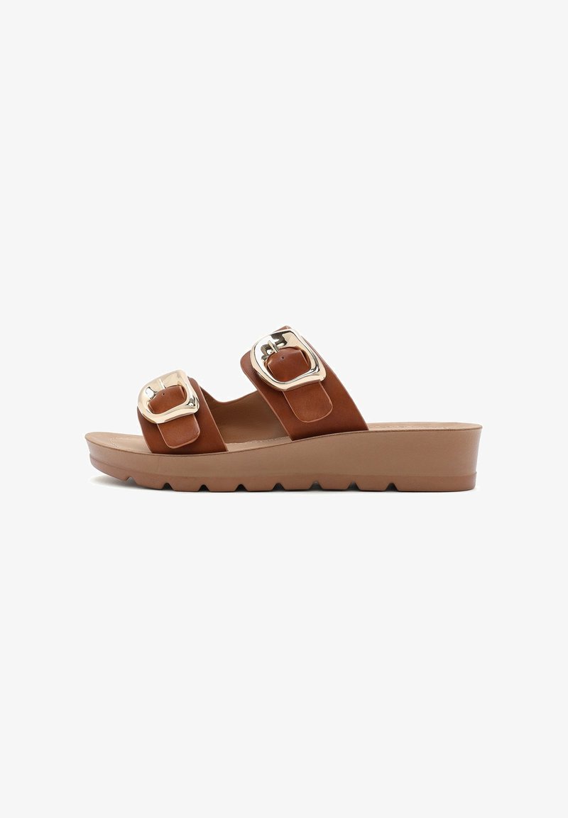 Sandales à glissière en cuir brun avec deux grandes boucles en argent, une semelle plateforme et une semelle texturée pour plus de grip.
