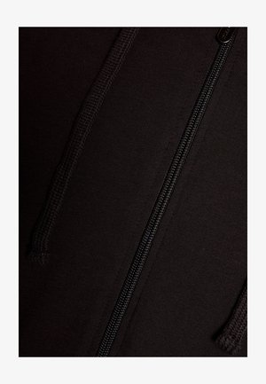 Giacca nera con zip realizzata in tessuto liscio, caratterizzata da una cerniera centrale e cuciture con trama lungo le giunture. Nessun motivo o grafica presente.