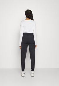 Fila RADIA TAPERED TRACK PANTS - Calças de fato de treino - black/bright white