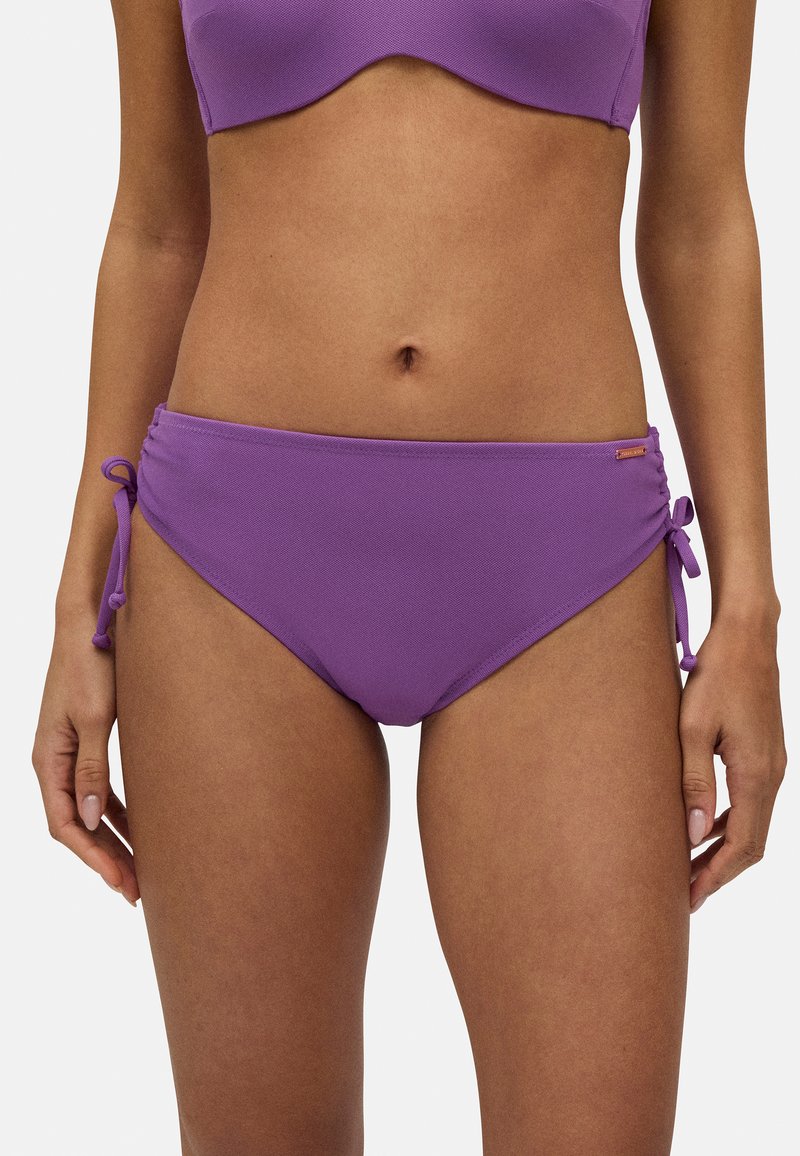 Bañador de bikini morado con una tela texturizada, que presenta lazos laterales ajustables y un sutil detalle de logo en la cadera derecha.