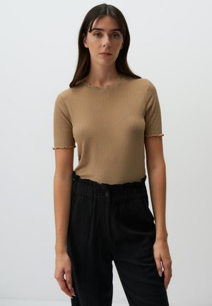 T-shirt khaki a coste con scollatura ondulata e maniche corte, abbinato a pantaloni neri a vita alta con vita arricciata.