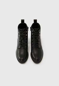 Czarne skórzane botki za kostkę z okrągłym noskiem, sznurowaniem z przodu, srebrnymi oczkami i bocznymi zamkami. Gładka faktura i płaska gumowa podeszwa.
