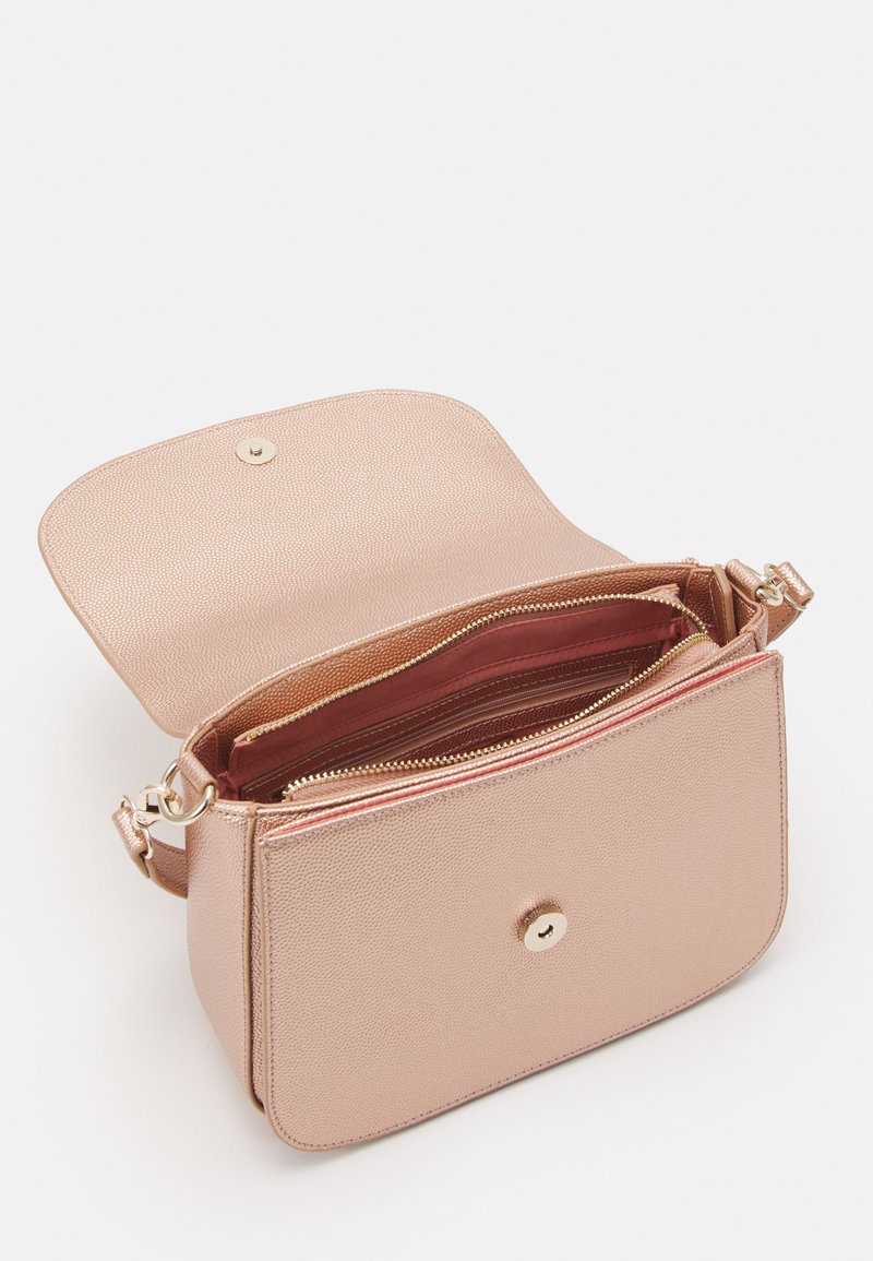 Sac à bandoulière en or rose avec une finition texturée, poches zippées et fermeture à pression magnétique. Intérieur spacieux avec plusieurs compartiments.