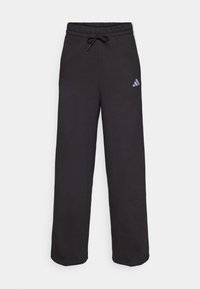 Pantaloni sport negri, cu talie elastică și șnur, dintr-un material moale. Prezintă un mic logo Adidas alb pe partea stângă.