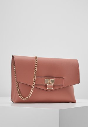 Pochette rectangulaire en cuir rose poudré avec une chaîne dorée et un cadenas décoratif en or sur le rabat avant, présentée sur une surface blanche.