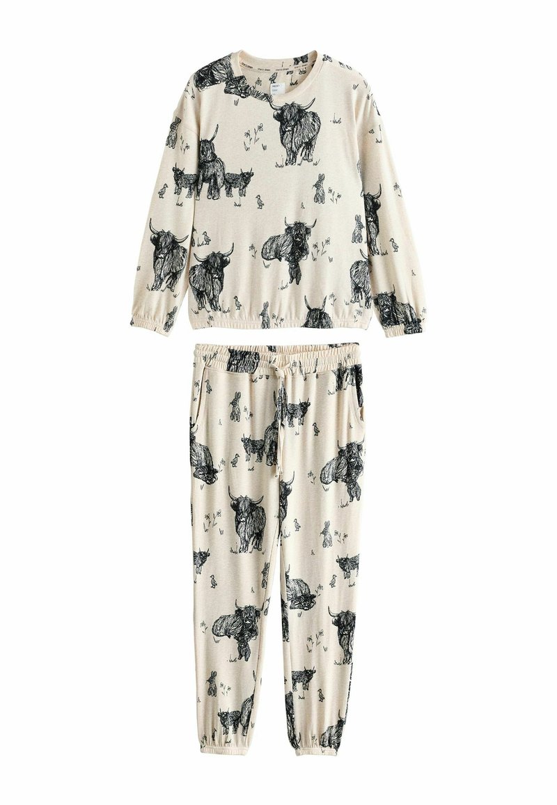 Beige lounge-sæt med en langærmet top og bukser med elastisk talje, begge dekoreret med sorte dyreillustrationer. Blødt, tekstureret stof.