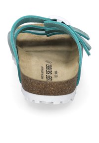Turkusowe sandały z zamszowymi paskami, korkową wkładką i białą gumową podeszwą. Posiadają metalowy klamrę oraz dekoracyjne frędzle.