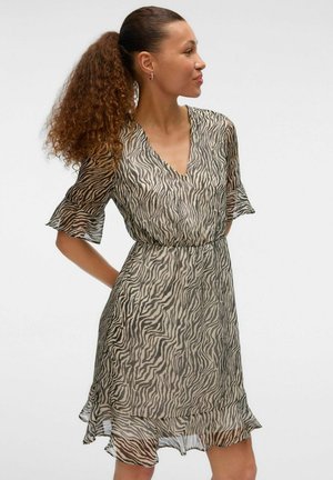 Robe à manches courtes avec un motif zèbre en beige et noir, dotée d'un décolleté en V et d'un ourlet évasé et superposé. Fabriquée en tissu léger et transparent.