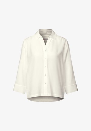 Bílá košile na knoflíky vyrobená z texturované tkaniny. Disponuje límečkem, rukávy po tři čtvrtiny a zakřiveným spodním lemem s bočními rozparky.