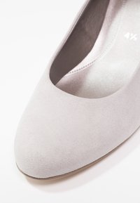 Ballerine en suede gris avec un bout arrondi et un intérieur lisse. Dispose d'un profil bas et d'un design minimaliste.