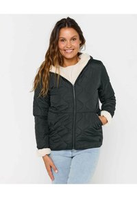 Veste matelassée noire avec une capuche et des poignets doublés en peluche blanche. Présente une fermeture éclair à l'avant et deux poches latérales. Extérieur lisse avec un contraste de texture.