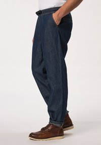 Blå denim joggerbyxor med elastisk midja och snörning, sidofickor och tapered bendesign, matchat med bruna snörskor.
