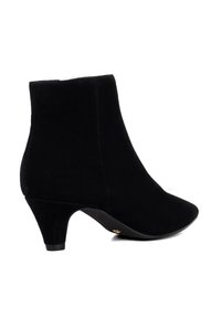 Black suede ankle boot with pointed toe and low kitten heel, viewed from the side on a white background.