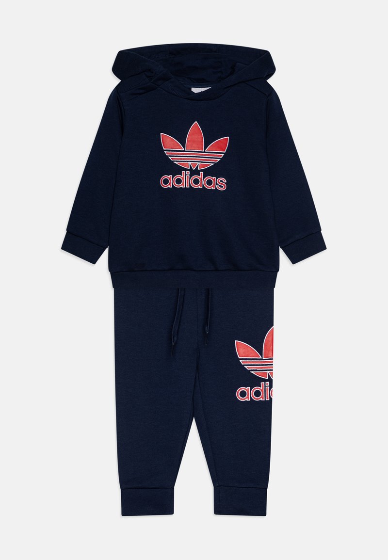 Navy blue hooded sweatshirt and matching pants. Features red Adidas logo on chest and thigh, made of soft, textured material, with ribbed cuffs.