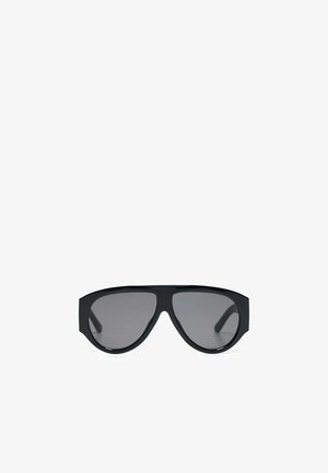 Czarne oversize okulary przeciwsłoneczne typu aviator z ciemnymi przyciemnianymi soczewkami, przedstawione na białym tle.