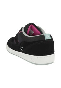 Mustat mokkakengät skateboardille, joissa on valkoinen kumipohja, harmaita yksityiskohtia, vaaleanpunainen sisustus ja tyylitelty logo sekä sivulla että takana.