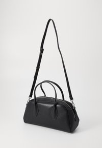 Mala de mão em pele preta com forma arredondada, duas alças superiores e uma alça ajustável para o ombro. Apresenta ferragens prateadas e fecho com zipper.