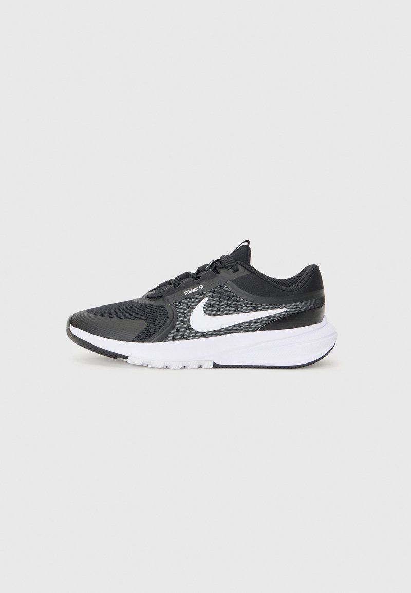 Chaussure de sport noire avec une tige en maille texturée, un swoosh Nike blanc et une semelle blanche rembourrée. Dispose d'une fermeture à lacets et d'un design de fit dynamique.