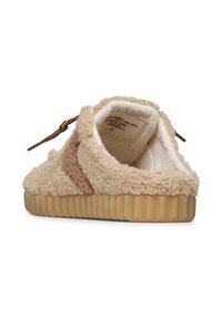 Pantofole beige con un esterno texturizzato e morbido, caratterizzate da un accento marrone. Presentano un rivestimento morbido e una suola in gomma rigata. Chiusura con lacci regolabili.