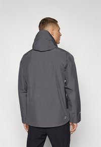 Grey waterproof jacket with an adjustable hood, smooth texture, and subtle branding. Features a mid-length design and elastic cuffs.