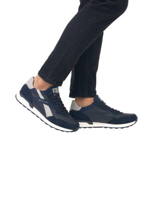Baskets bleu marine avec des panneaux en daim et en mesh, dotées de perforations, d'accents gris contrastants et de semelles blanches, mettant en avant un design sportif.