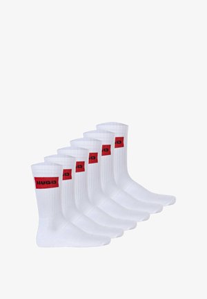Sechs Paar weiße Baumwollsocken mit einem gerippten Design und einem roten Quadrat-Logo, auf dem "HUGO" in Schwarz gedruckt ist.