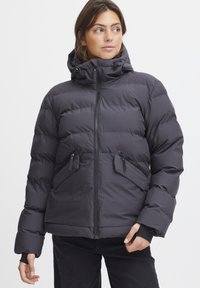 Giubbotto imbottito grigio scuro con cappuccio, tasche con zip e polsini elastici. Presenta un design trapuntato per isolamento e comfort.