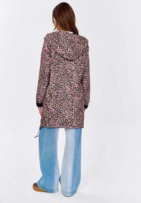 Sako s leopardím vzorem a kapucí, růžové akcenty, volný střih a stahovací spodní lem, spárované s širokými denimovými kalhotami.