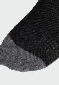 Calcetín negro con una suave punta gris. Fabricado con tejido texturizado, presenta un talón reforzado y un diseño sin costuras para mayor comodidad.
