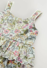 Robe sans manches pour enfant avec imprimé floral pastel et bordure en dentelle sur les bretelles et ourlet volanté.