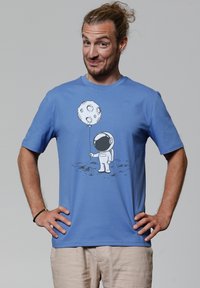 Blauwe katoen t-shirt met een bedrukte astronaut die een maanvormige ballon vasthoudt. Korte mouwen, ronde halslijn, casual pasvorm en eenvoudig ontwerp.