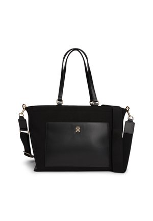 Sac cabas noir avec doubles poignées et bandoulière réglable, avec une poche avant en cuir dotée d'un petit emblème logo doré.