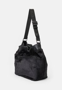 Borsa in pelliccia sintetica nera con una forma strutturata, dettagli in pelle nera, tracolla regolabile e una texture morbida. Presenta dettagli del logo sulla tracolla.
