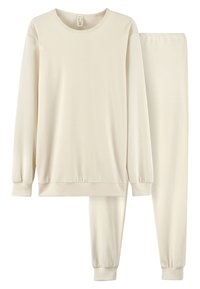 Beige bomullsnattkläder i set som består av en långärmad topp med ribbade mudd och matchande byxor med elastisk midja som är smalare nertill. Mjuk och slät textur.