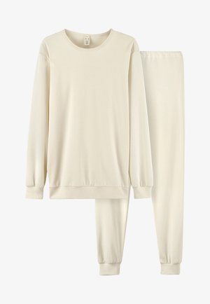 Beige Baumwoll-Loungewear-Set mit einem Langarm-Oberteil mit gerippten Bündchen und passenden, elastisch taillierten Hosen. Weiche und glatte Textur.