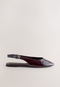 Chaussure plate slingback en cuir verni bordeaux foncé, bout pointu et fermeture à boucle argentée sur fond neutre.