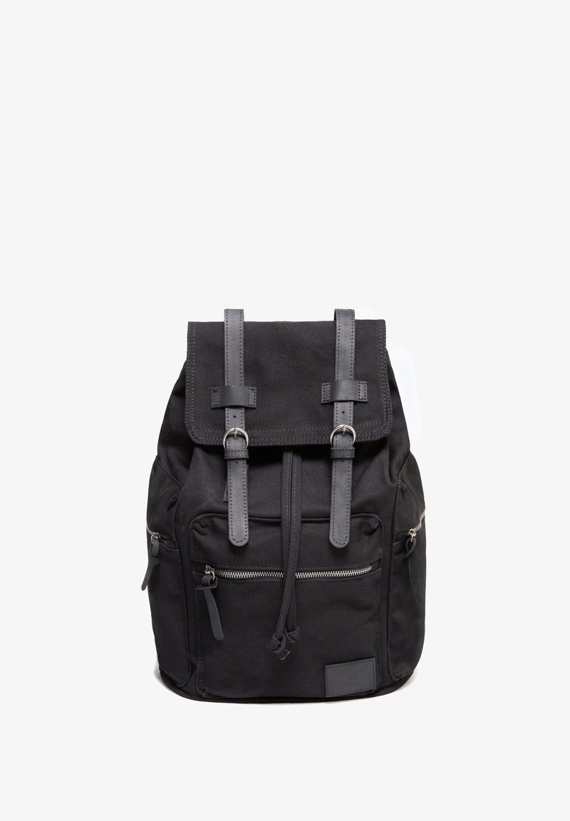 Zaino in tela nera con un lembo superiore dotato di due cinghie, tasche frontali con zip e tasche a strappo, e un pannello in pelle sintetica testurizzata.