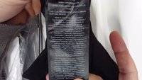 Ozdoba na oblečenie s viacjazyčným textom zobrazujúca značku, model, krajinu výroby (Kambodža) a zloženie látky (50 % recyklovaný polyester).