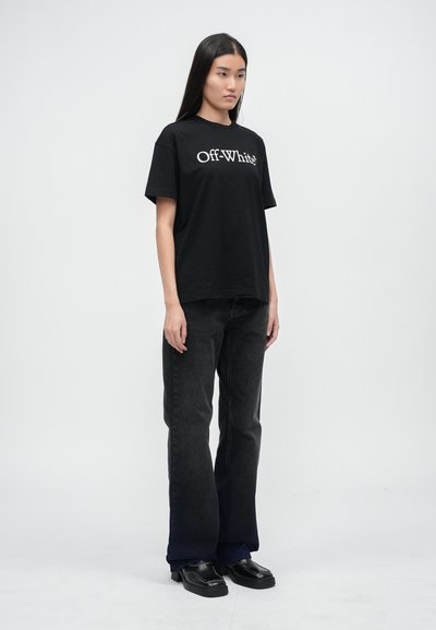 Czarna bawełniana koszulka z logo "Off-White" na piersi, w połączeniu z ciemnymi dżinsami i czarnymi skórzanymi butami. Prosty, luźny krój.