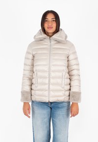 Giacca imbottita color beige chiaro con colletto alto, polsini foderati in pelliccia e chiusura con zip. Tessitura morbida e dettaglio di trapuntatura orizzontale in tutto il capo.