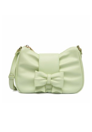 Bolso pequeño de color verde pálido con un lazo frontal y una correa de hombro ajustable, presentado sobre un fondo blanco.