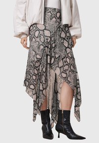 Asymmetrische rok in slangenprint, met gelaagde ruches, in een mengsel van beige en zwart, gecombineerd met zwarte enkellaarzen.