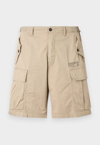 Pantaloni scurți cargo bej cu mai multe buzunare cu nasturi, cleme laterale reglabile, bucle pentru curea și un mic logo imprimat pe buzunarul de pe coapsa dreaptă.