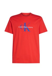 Camiseta de algodón roja con un gráfico azul de "CK" y el texto "Calvin Klein Jeans" centrado en el frente. Cuello redondo, manga corta.