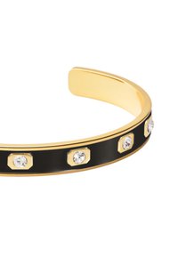 Bracelet jonc en tonalité dorée avec un bandeau en émail noir, rehaussé de détails hexagonaux et de cristaux transparents répartis uniformément sur la surface.