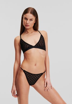 Zwart lingerie set met een doorschijnende stof met een herhalend patroon, triangelsnij bralette met dunne bandjes en bijpassende laag uitgesneden thong.